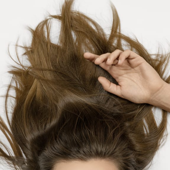 Nahaufnahme von Haar und Hand als Kopfhautpflege-Visual