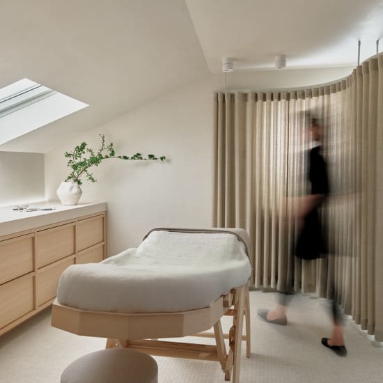 Atmosphärischer Behandlungsraum mit Liege und unscharfer Person