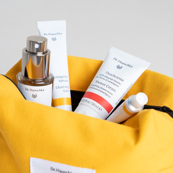 Dr. Hauschka Naturkosmetik Duschcreme und Reinigungsbalsam in gelber Tasche
