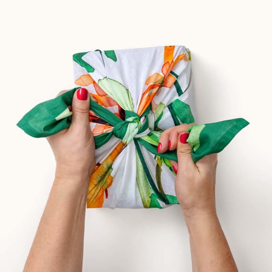 Hände binden Knot Wrap mit floralem Muster, rote Nägel