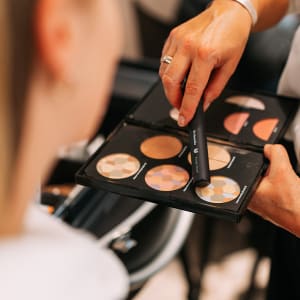 Dr. Hauschka Naturkosmetik Make-up-Palette mit Puderpinsel, atmosphärisches Bild mit zwei Personen