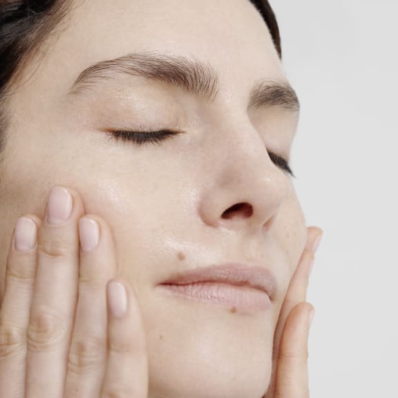 Atmosphärisches Bild einer Person mit geschlossenen Augen, Hand an der Wange