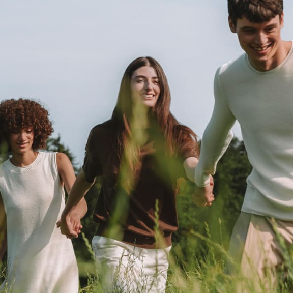 Atmosphärisches Bild mit drei Menschen auf einer Wiese